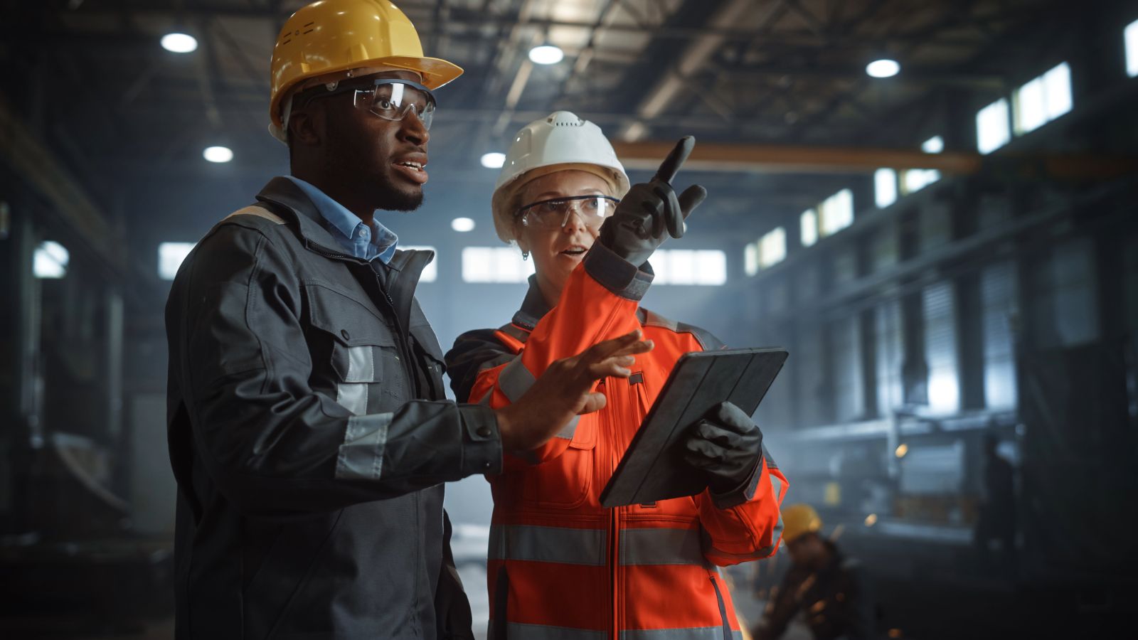 Two engineers discussing in steel metal manufacturing factory with digital tablet