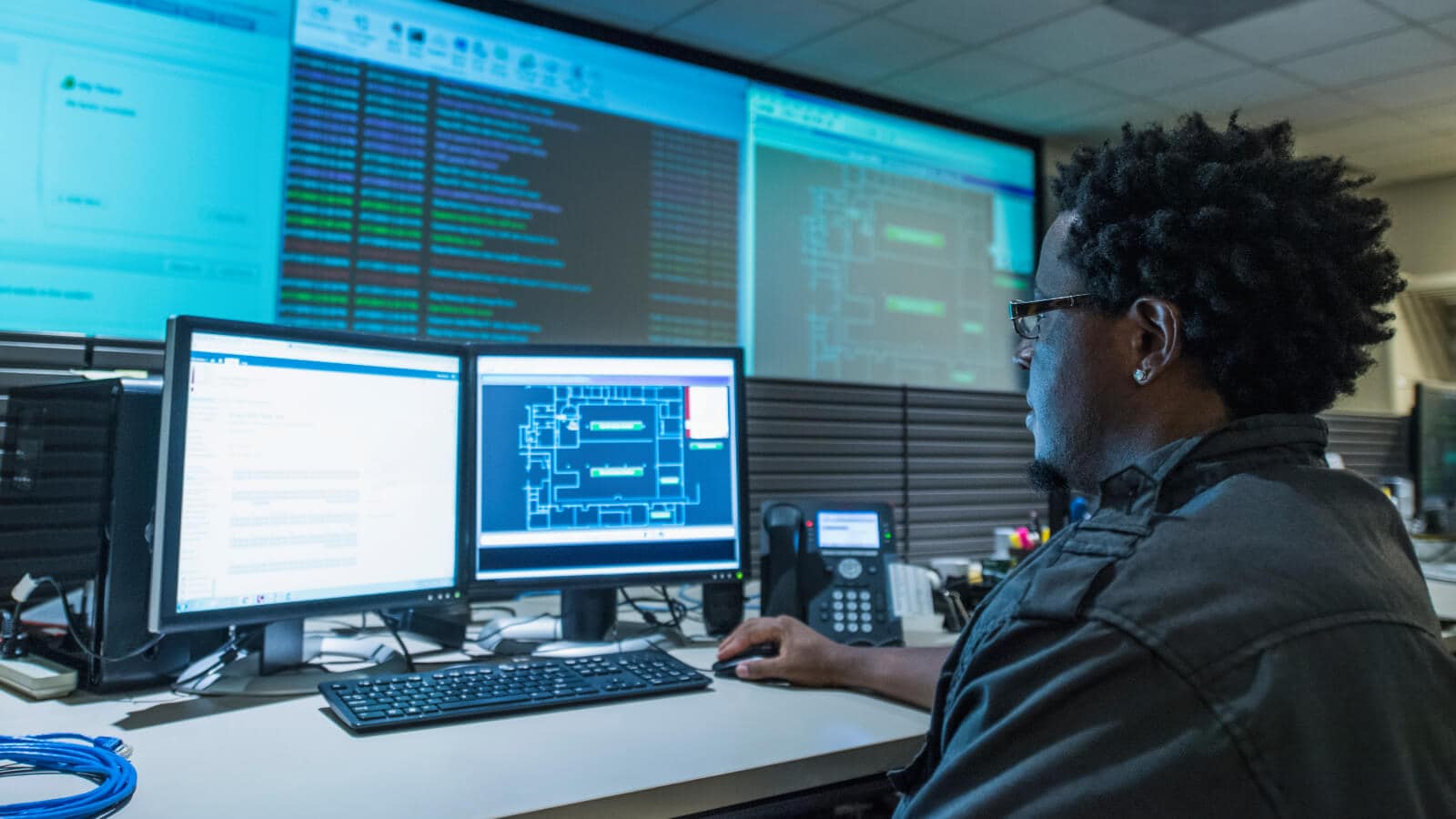 man working on code on a laptop