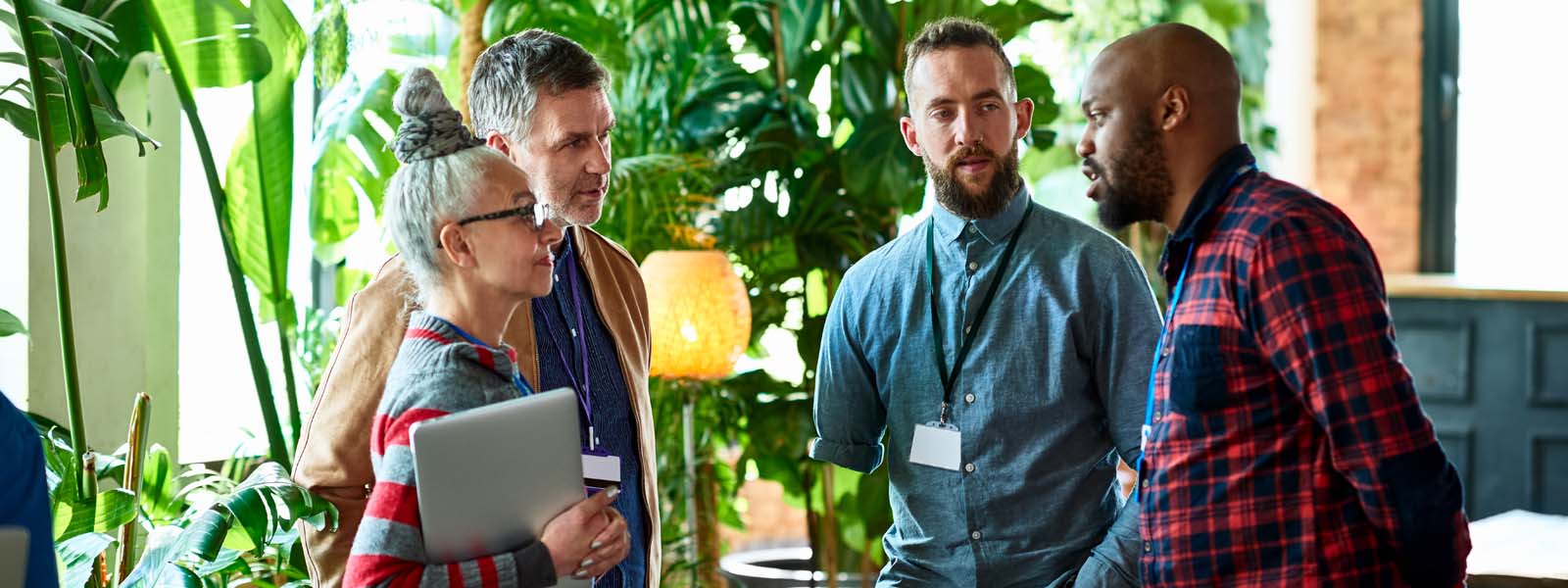 colleagues talking with office plants in background